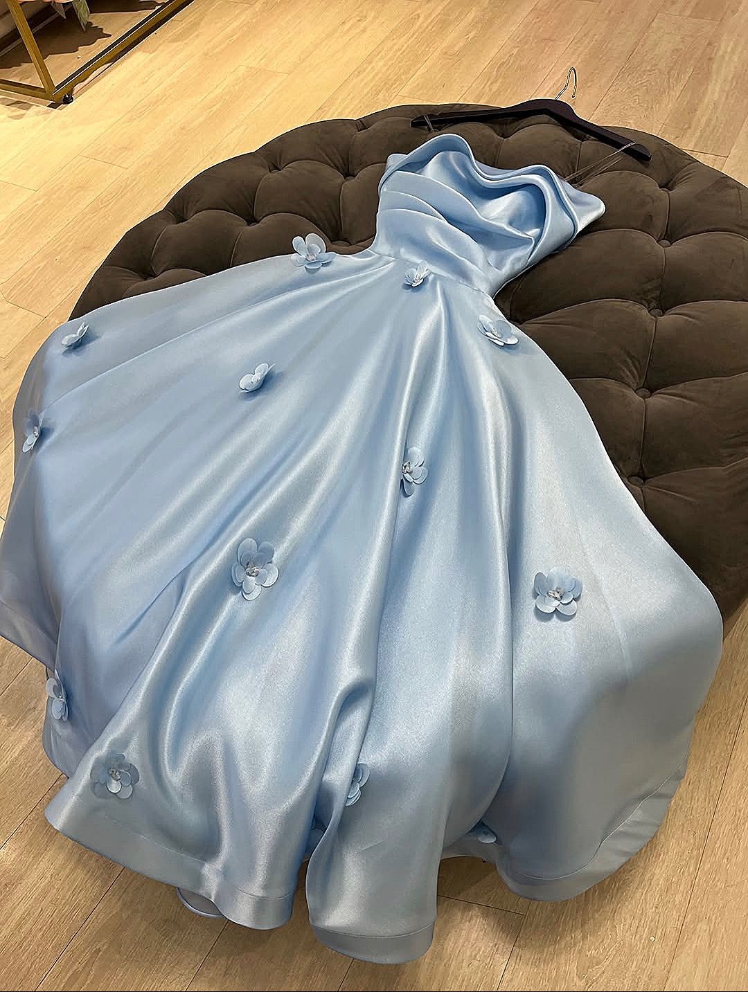 Robe de bal longue bleu pâle, coupe trapèze, sans manches, plissée, en satin orné d'appliqués et de bretelles. Référence C6430.