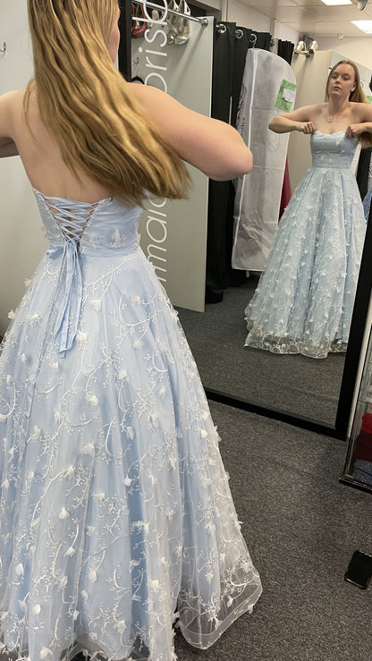 Robe de bal longue bleu pâle, coupe trapèze, sans manches, en satin et tulle appliqué, ornée d'appliqués. Référence C6350.