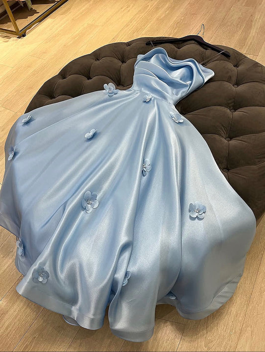 Robe de bal longue bleu pâle, coupe trapèze, sans manches, plissée, en satin orné d'appliqués et de bretelles. Référence C6430.