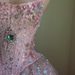 Robe de bal longue rose, coupe trapèze, sans manches, en tulle à sequins et perles, ornée de perles. Référence C6452